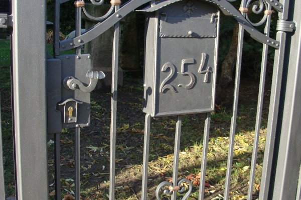 Kovaná branka s integrovanou poštovní schránkou.