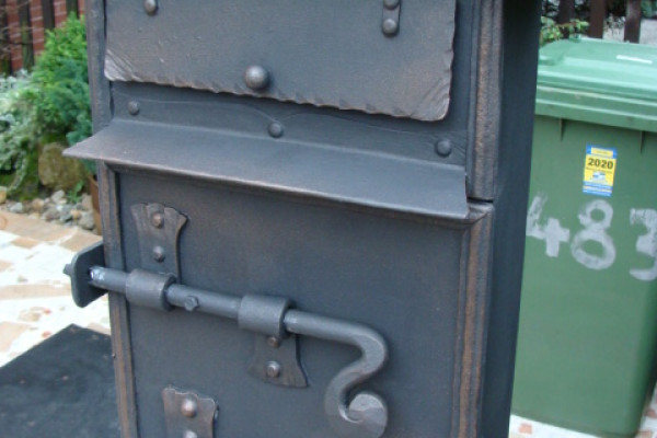 kovaná poštovní schránka na sloupku.